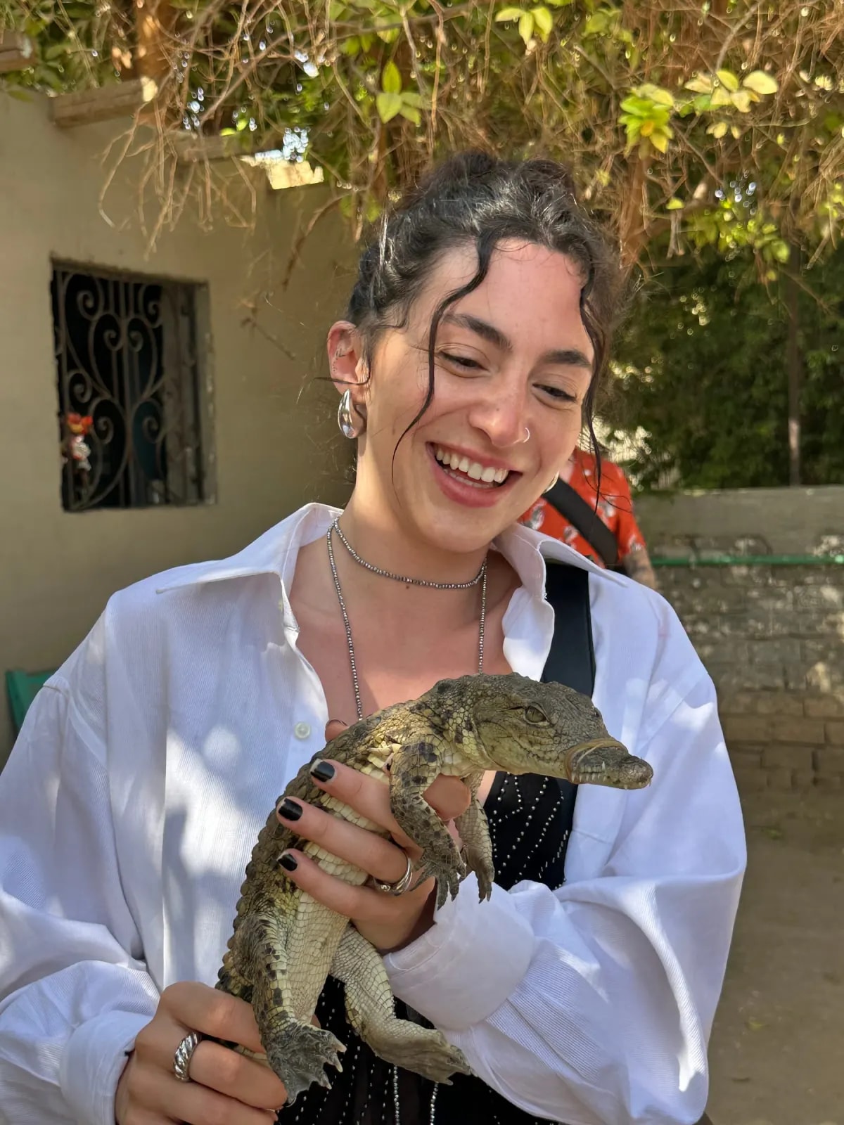 A guest holding a baby crocodile in a Nubian village